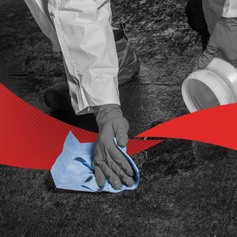 Una persona in abbigliamento protettivo pulisce un pavimento scuro con un panno blu WypAll® X60 General Clean a estrazione centrale (1 rotolo, 150 fogli) della Kimberly-Clark GmbH. Un contenitore bianco e grafica rossa sottolineano l'efficiente estrazione centrale.