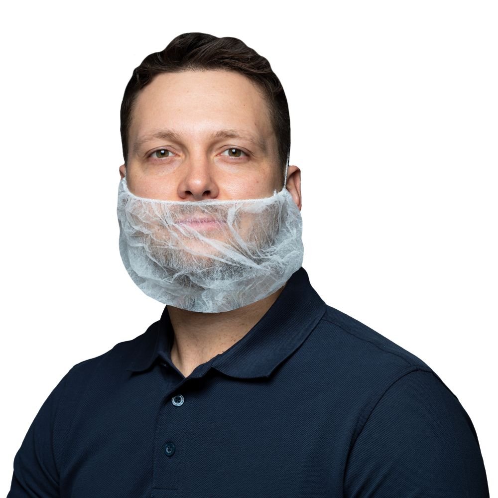 Un uomo con una polo scura e una barba trasparente di tessuto non tessuto fissata al viso (maschera per barba NITRAS grande) guarda direttamente nella fotocamera su uno sfondo chiaro.