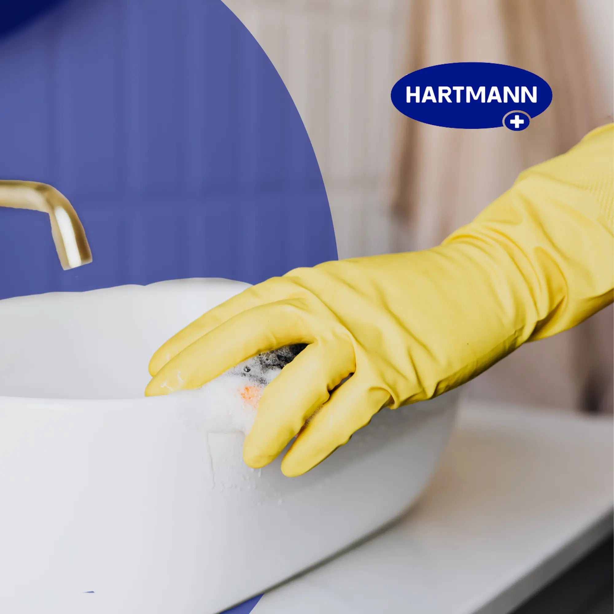 Eine Person mit einem gelben Gummihandschuh schrubbt ein weißes Waschbecken mit einem Schwamm. Auf dem Waschbecken befindet sich Seifenschaum, und ein goldener Wasserhahn ist zu sehen. Das Hartmann-Logo erscheint in der oberen rechten Ecke.
