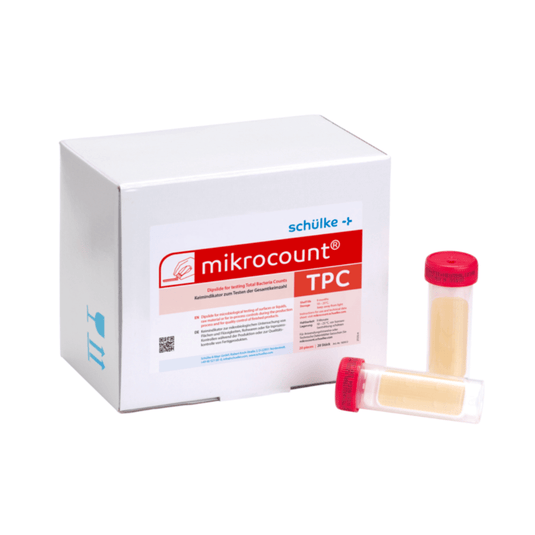 Una scatola bianca con la scritta «Schülke & Mayr GmbH Mikrocount® TPC, terreno di coltura | Confezione (20 pezzi)», con un logo e una descrizione del prodotto accanto a due fiale per test microbiologici, una con tappo giallo e l’altra con tappo trasparente.