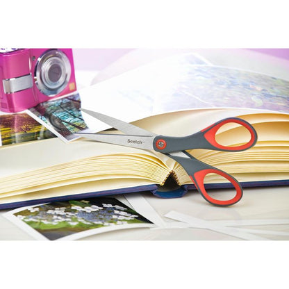 Le forbici di precisione rosse Scotch™ di 3M Deutschland GmbH si trovano su un album fotografico aperto con foto. Sul tavolo ci sono anche una fotocamera rosa e foto sciolte.
