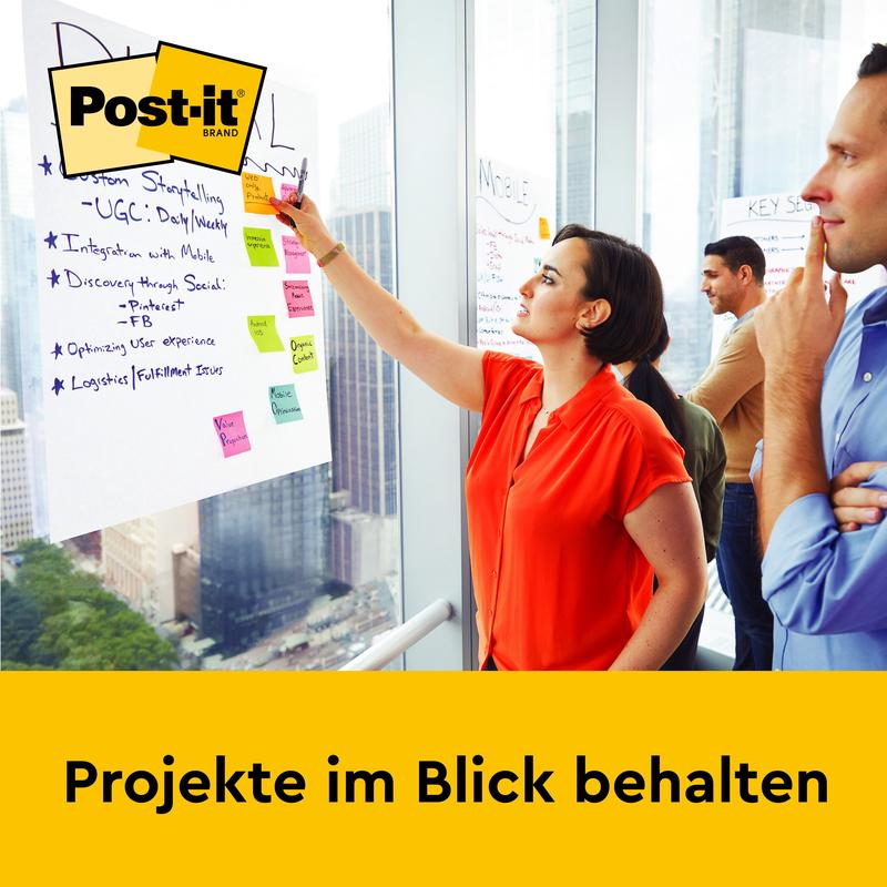 Una donna con una camicia rossa scrive su un Post-it® Super Sticky Mini Meeting Chart 577SS (38 x 45,7 cm, 20 fogli) di 3M Deutschland GmbH, mentre tre persone guardano in un ufficio moderno. Il testo dice "Tenere d'occhio i progetti", sopra il logo del marchio Post-it.