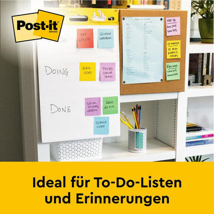Su una scrivania si trova il Post-it® Super Sticky Mini Meeting Chart autoadesivo, 38x45,7cm, di 3M Deutschland GmbH, con una lista di cose da fare colorata. Vicino c'è un'agenda blu e i libri riempiono lo scaffale sottostante. Testo: "Ideale per liste di cose da fare e promemoria."