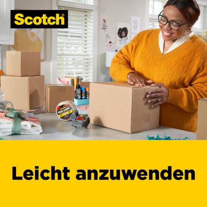 Eine Person mit Brille und gelbem Pullover verwendet das 3M Deutschland GmbH Scotch® Box Lock™ Verpackungsklebeband 3950-LR3-DC (48 mm x 50 m, 3 Rollen/Packung), um einen Karton in einem hellen, aufgeräumten Raum mit einer Kartonverpackung zu verschließen; der Text lautet "Leicht anzuwenden".