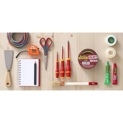 Una forbice di precisione rossa Scotch™ di 3M Deutschland GmbH è disposta su una superficie di legno con vari strumenti e articoli di cancelleria come filo colorato, metro a nastro, cacciavite, nastro adesivo, spatola, quaderno a spirale, matita, tubo di colla e pennello.