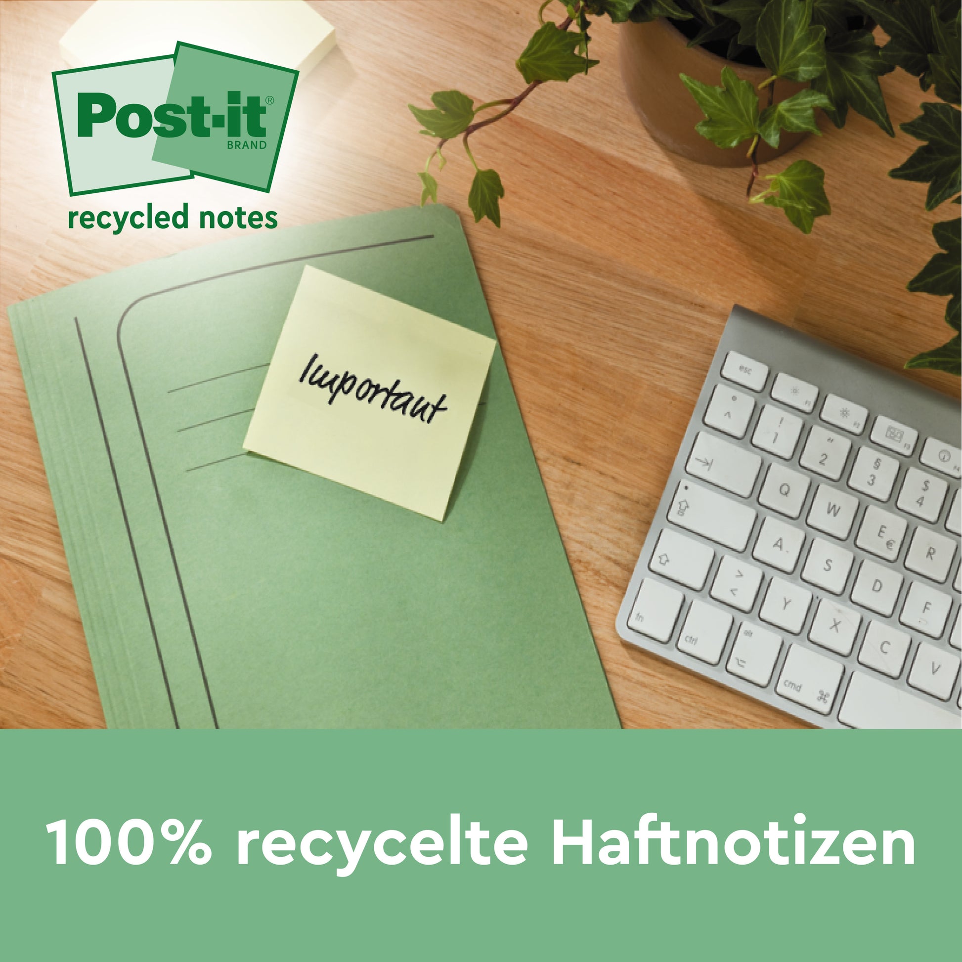 Ein grüner Ordner mit einer Post-it® Super Sticky 100 % Recycling Notiz (47,6 mm x 47,6 mm, 70 Blatt/Block, 100% PEFC) von 3M Deutschland GmbH liegt neben einer weißen Tastatur und einer Pflanze. Auf dem Zettel steht "recycelte Notizen".