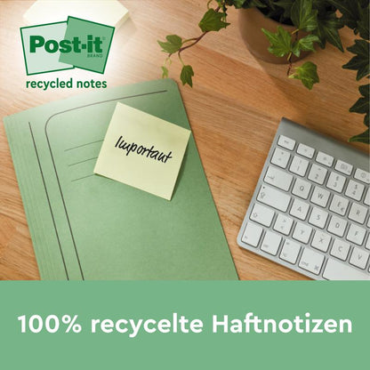 Una cartella verde con un foglietto adesivo Post-it® Recycling Z della 3M Deutschland GmbH con la scritta "importante" si trova su un tavolo di legno accanto a una tastiera e una pianta. Il testo sottostante recita: "Foglietti adesivi riciclati al 100%, 76x76mm, 100 fogli/blocco, 100% PEFC.