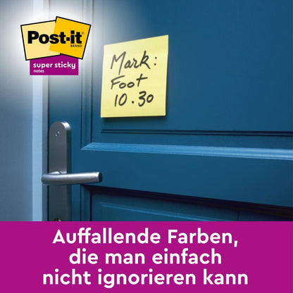 Un giallo 3M Post-it® Super Sticky Note (Giallo, 76x127mm, Promozione) con la scritta "Mark: Foot 10.30." è attaccato a una porta blu sopra la maniglia. La nota mostra il logo Post-it e testo tedesco in una barra viola in basso.