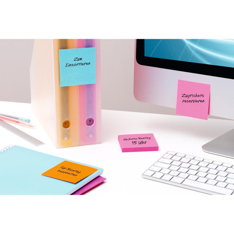 Sulla scrivania ci sono un computer, una tastiera, cartelle, un righello, un quaderno e cubi di Post-it® Super Sticky Notes colorati (76 x 76 mm, 100% PEFC) di 3M Deutschland GmbH per promemoria delle riunioni e organizzazione.