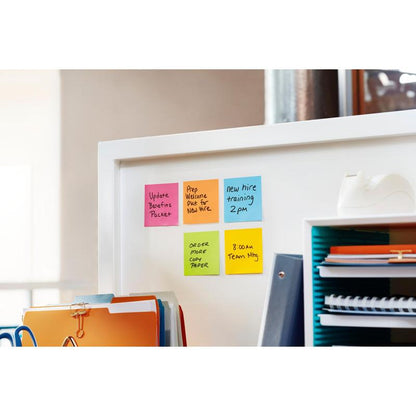 Su una parete divisoria bianca dell'ufficio ci sono sei colorati Post-it® Super Sticky Z-Notes (14 blocchi + 2 gratis, vari colori, 76x76 mm, 90 fogli/blocco, di 3M Deutschland), raccoglitori, un organizer blu con documenti e un dispenser di nastro adesivo.